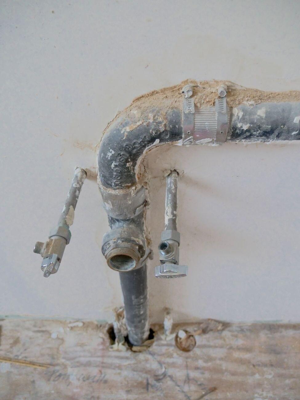 Yenileme sırasında açılan duvarda ortaya çıkan eski galvaniz borular ve vanalar