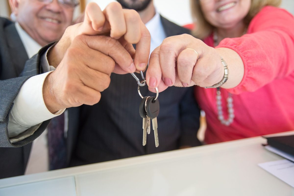 Bir daire anahtarını elden ele teslim eden kişiler