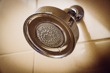 Banyo duvarına takılı metal duş başlığı yakın plan