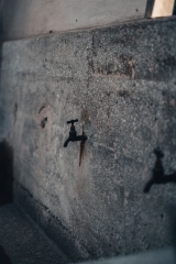 Beton duvarda aşağı doğru pas izi bırakmış tek vana