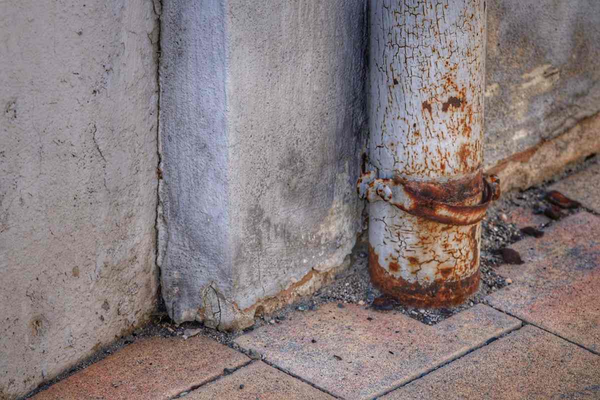 Duvar dibinde paslanmış, kelepçesi çürümüş boru