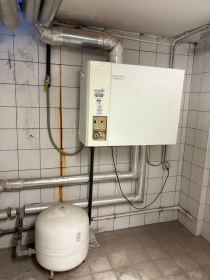 Duvar tipi kombi, altında genleşme tankı ve sarı gaz hattı