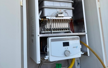 Kapağı açık gaz cihazında brülör sırası, pirinç enjektörler ve lamelli eşanjör