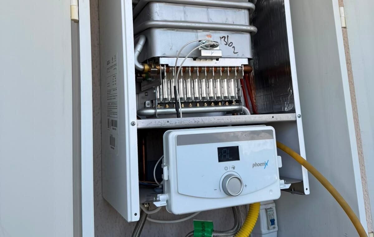 Kapağı açık gaz cihazında brülör sırası, pirinç enjektörler ve lamelli eşanjör