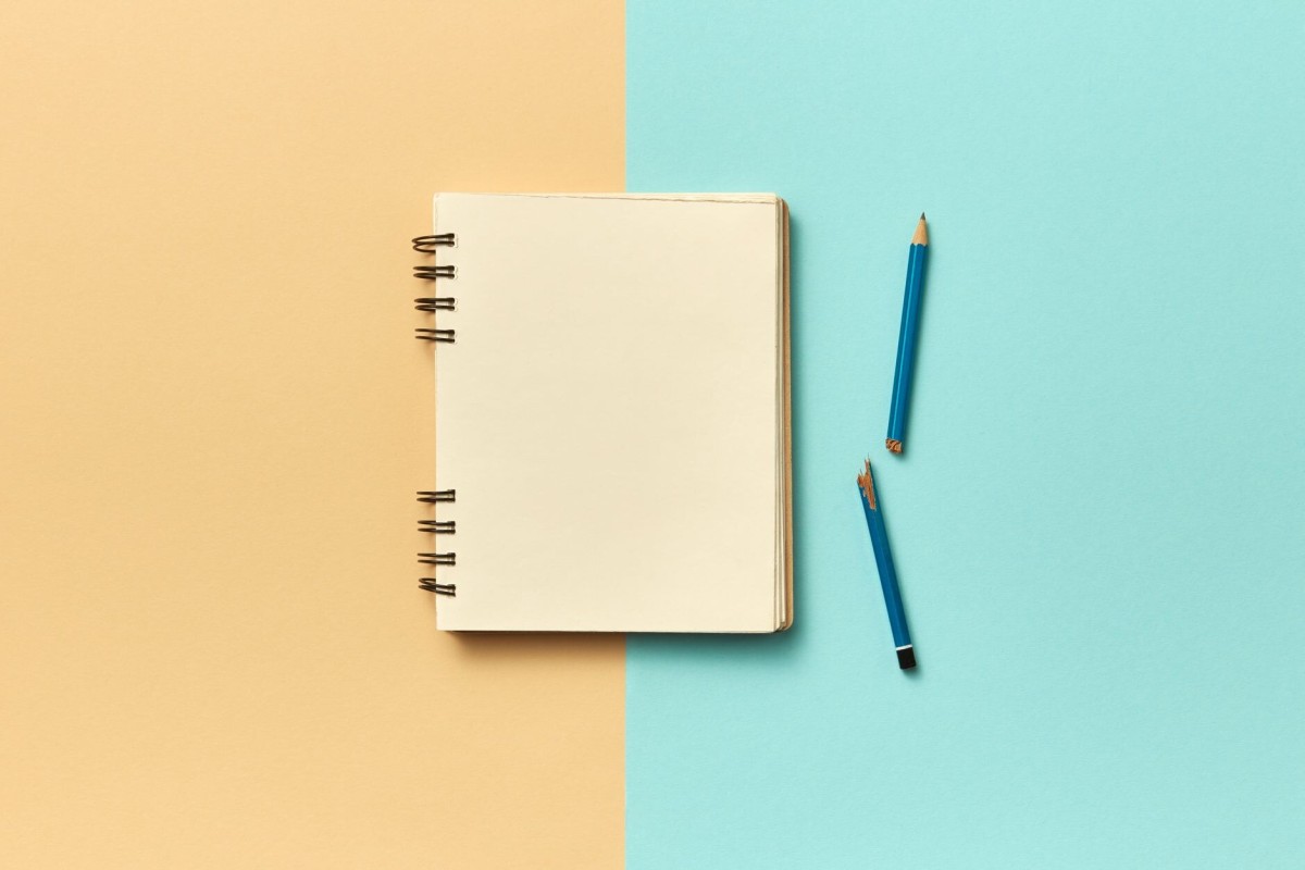 İki renge bölünmüş zeminde açık defter ve kırılmış kalem