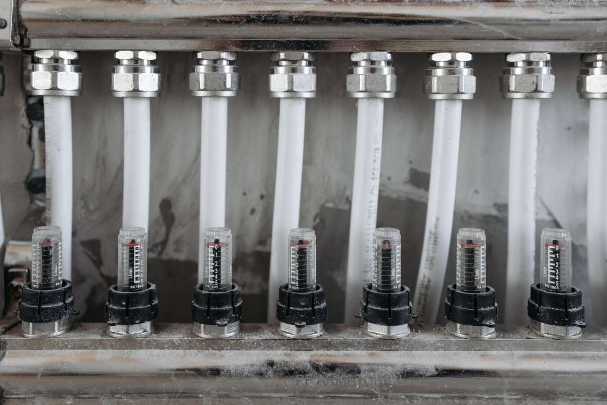 Kolektör üzerinde sıralanmış debimetreler ve devre boruları
