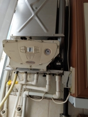 Kombi altında bakır borular ve sarı gaz hattı
