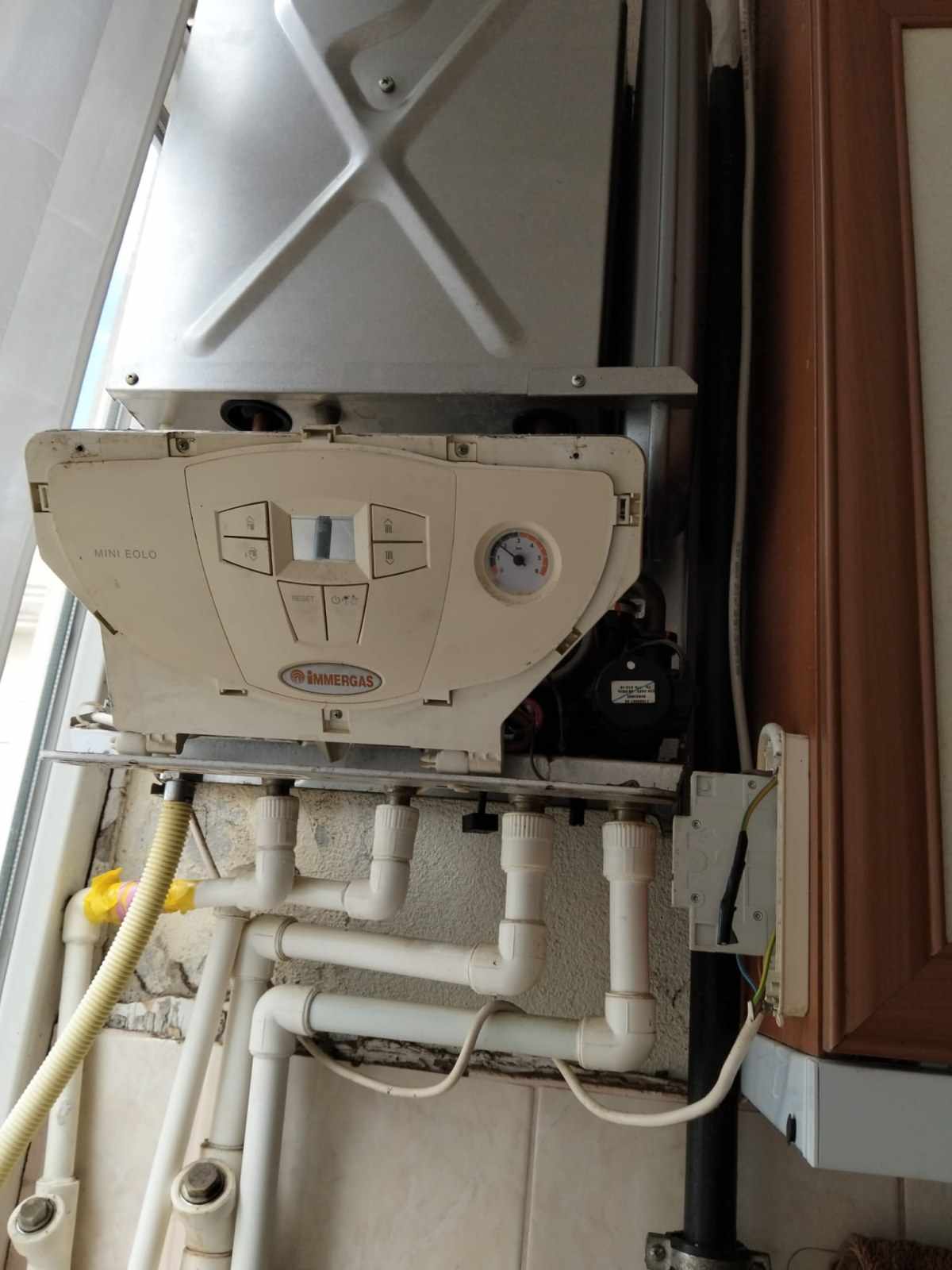 Kombi altında bakır borular ve sarı gaz hattı
