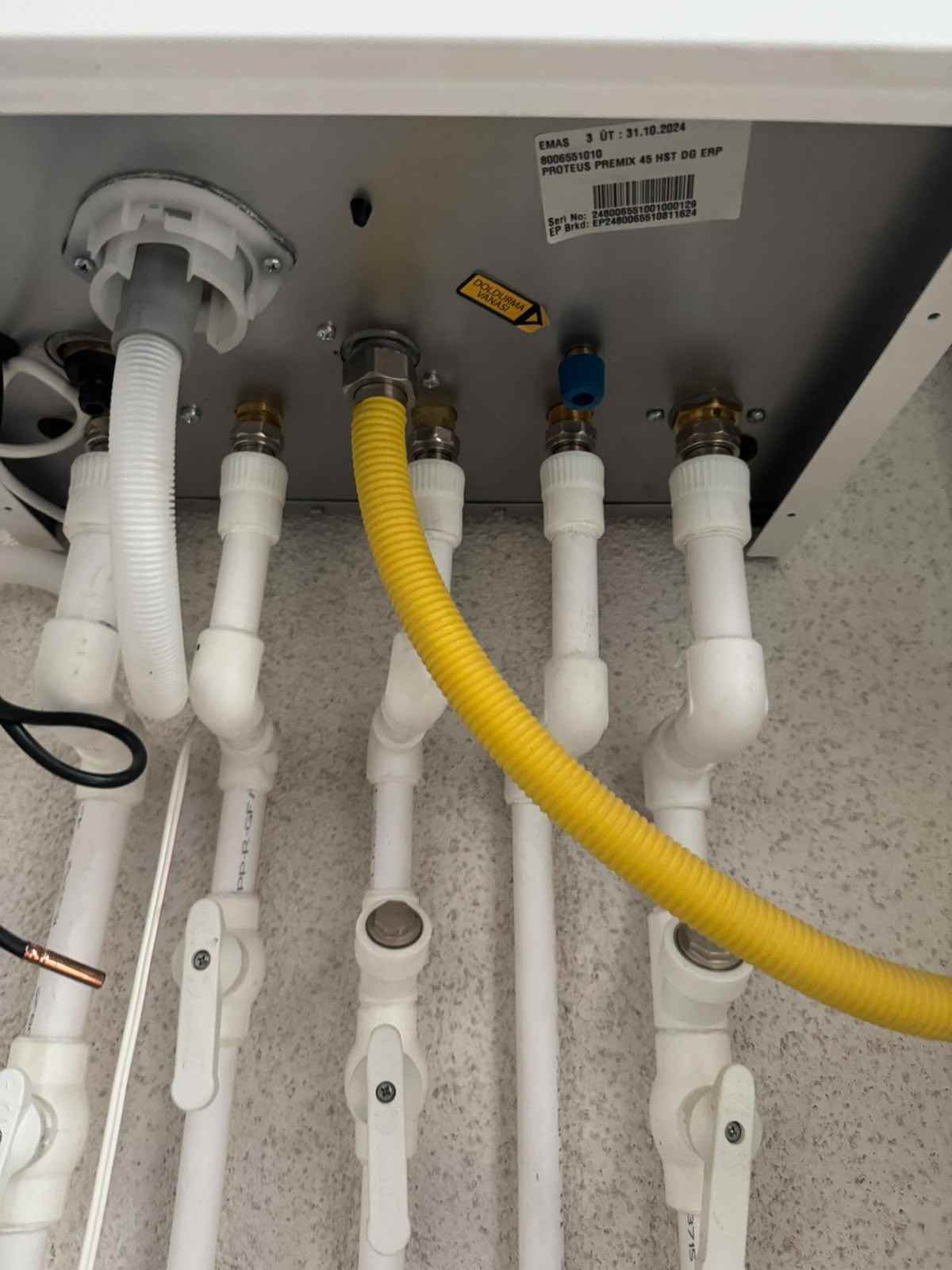 Kombi altında PPRC borular ve sarı gaz hortumu