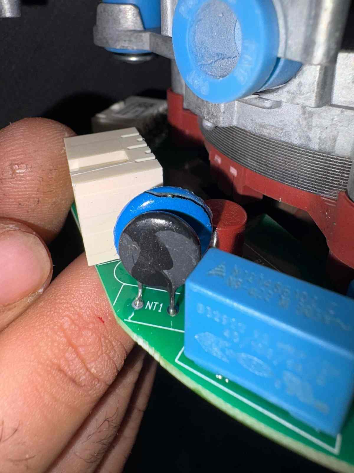 Kombiden sökülmüş elektronik kart teknisyenin elinde, NT1 sensör yuvası görünüyor