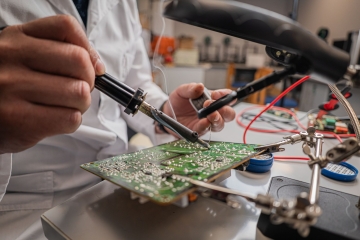 Teknisyen kombi elektronik kartını tezgahta lehimliyor