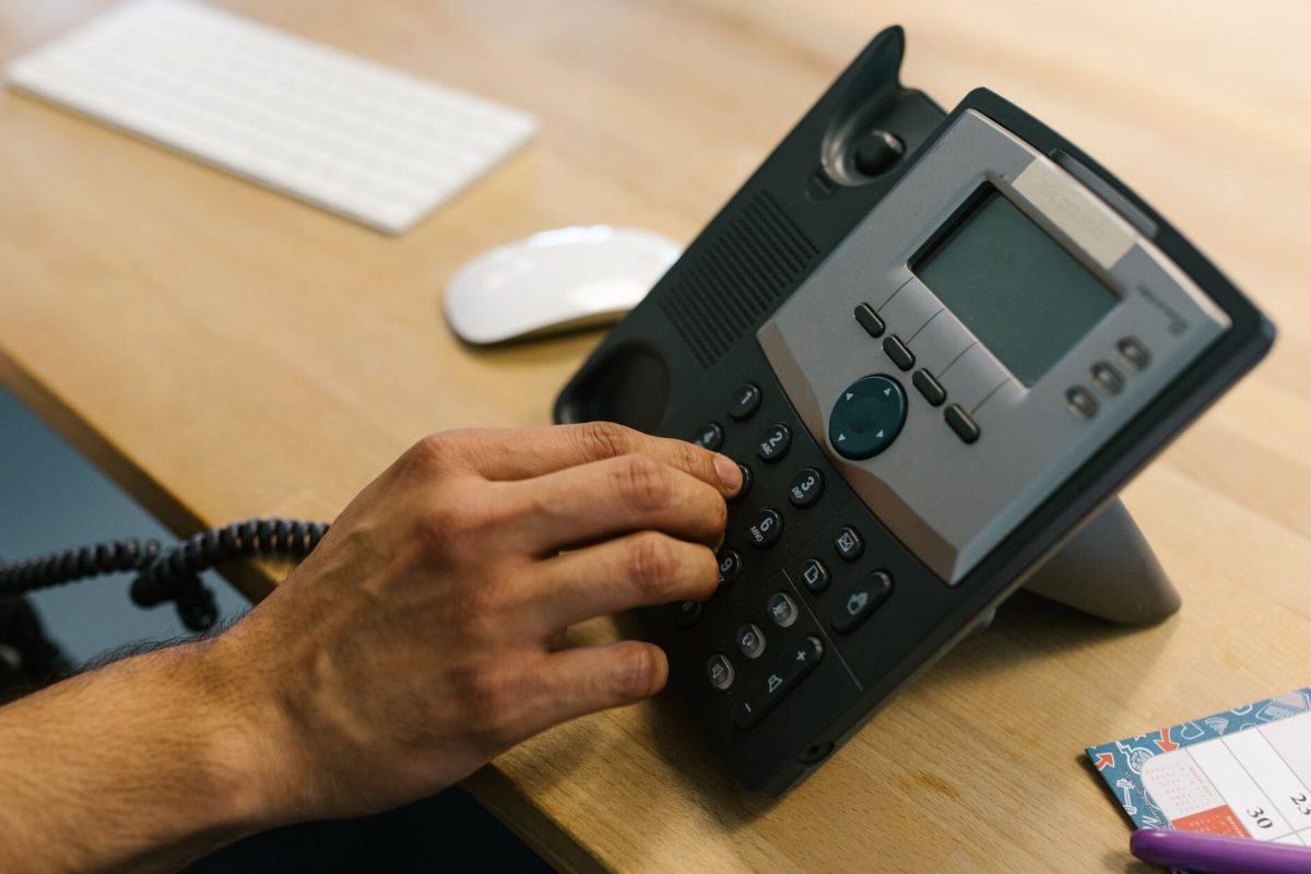 Masa telefonunda numara tuşlayan bir el