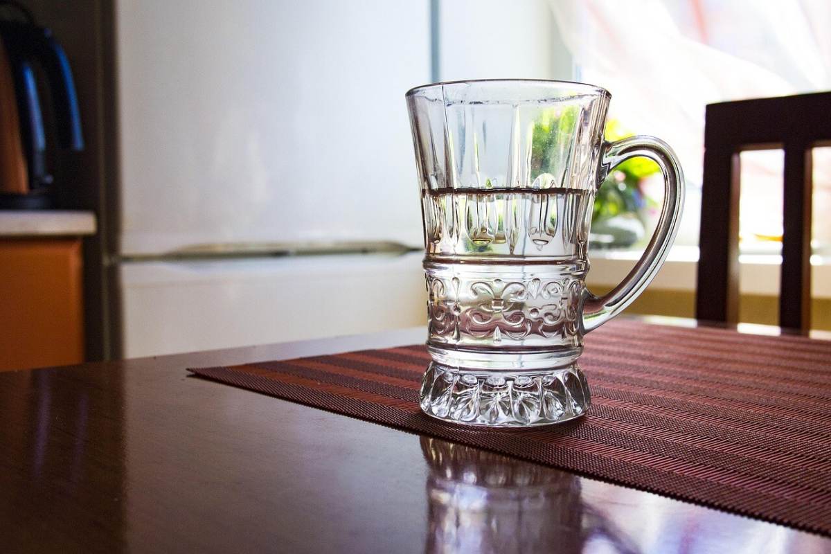 Mutfak masasında yarısı boşalmış bir su bardağı